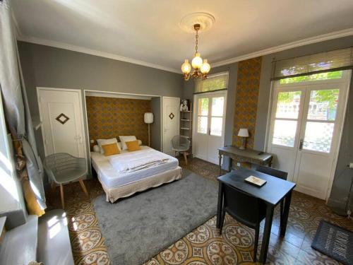 a bedroom with a bed and a table and a desk at Côté Cité appartements - Parking privé - 100m Cité médiévale in Carcassonne