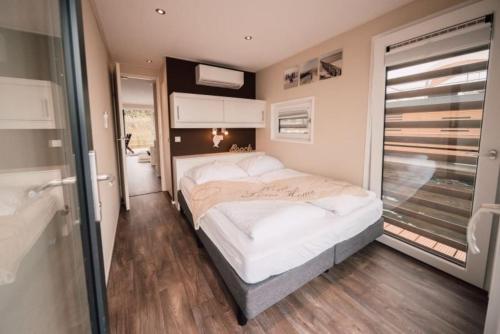 a bedroom with a large bed and a bathroom at Hausboot Seestern in Klitten