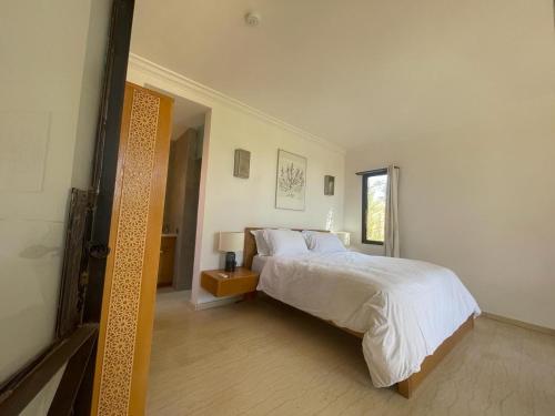 a bedroom with a large white bed and a window at Kech-Montana in Mzoudia