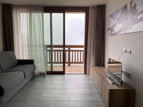 a living room with a couch and a television at Appartamento trilocale luxory,sulle piste da sci in Bormio