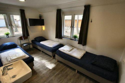 a room with two beds and a sink at Familiehuis De Eekhoorn - 16p in Otterlo