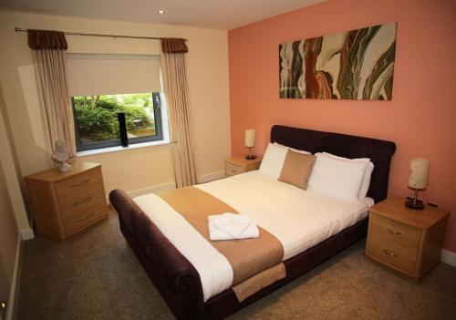 a bedroom with a large bed and a window at The Grove - Properties Unique in Newcastle upon Tyne