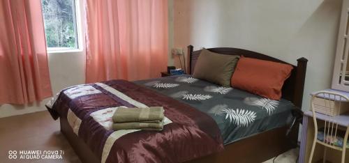 a bedroom with a bed and a crib at EBH2 Guesthouse in Kampong Alor Gajah