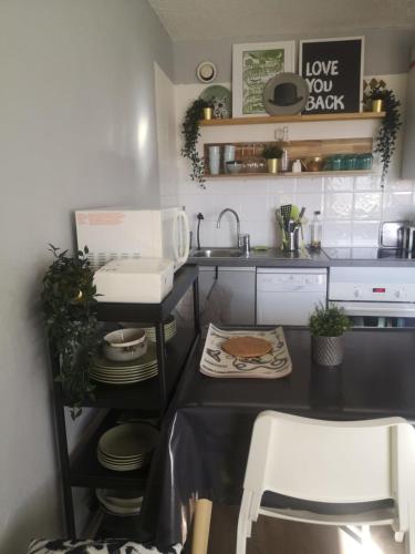 - une cuisine avec un évier et un comptoir avec une table dans l'établissement #AH5 Le Soleil des Jeux, à Huez