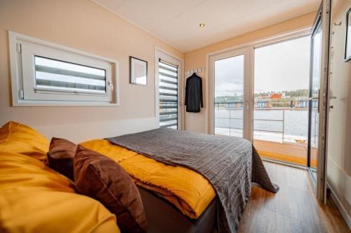 a bedroom with a bed and a large window at Hausboot Skyline in Klitten