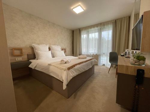 ein Hotelzimmer mit einem Bett mit Handtüchern darauf in der Unterkunft Хотел Балач in Godech