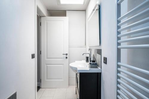 a white bathroom with a sink and a mirror at Cherubini Palace Thematic Apartment in Florence