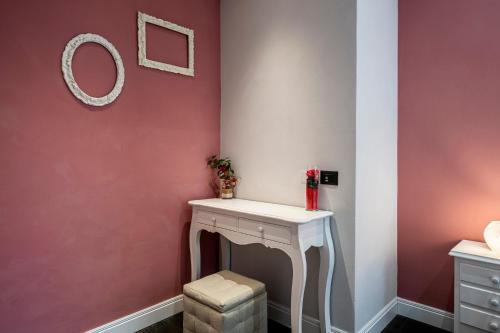a dressing room with a white vanity and red wall at Cherubini Palace Thematic Apartment in Florence