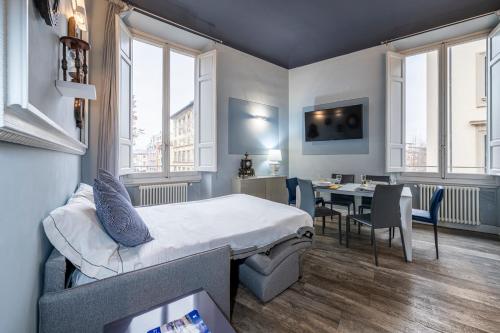 a bedroom with a bed and a dining room with a table at Cherubini Palace Thematic Apartment in Florence