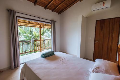 ein Schlafzimmer mit einem Bett und einem großen Fenster in der Unterkunft Chales do Ademir in Ilhabela