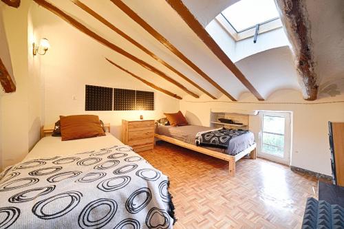 a bedroom with two beds and a vaulted ceiling at agradable casa rural con chimenea y aire acondicionado in Vilavert