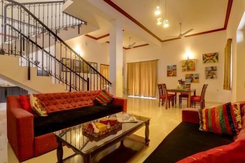 a living room with a couch and a table at JAQK Holidays - 9BHK Villa for Big Groups, Private Pool-WiFi-Cartaker-Parking, North Goa in Baga