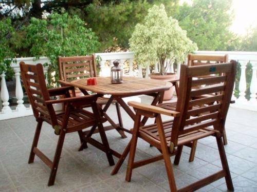 a wooden table with two chairs and a tea kettle on it at Studios Irene in Skala