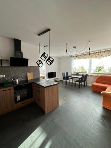 a kitchen and living room with a couch and a table at Apartamenty Czerwona Stodoła in Kłodzko