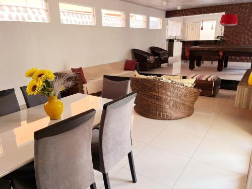 uma sala de jantar e sala de estar com mesa e cadeiras em CASA TEMPORADA COM PISCINA PRIVATIVA no Guarujá