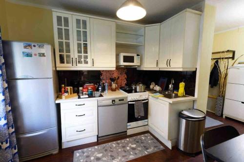 a kitchen with white cabinets and a refrigerator at Enzo apartment-1 in Ulaanbaatar