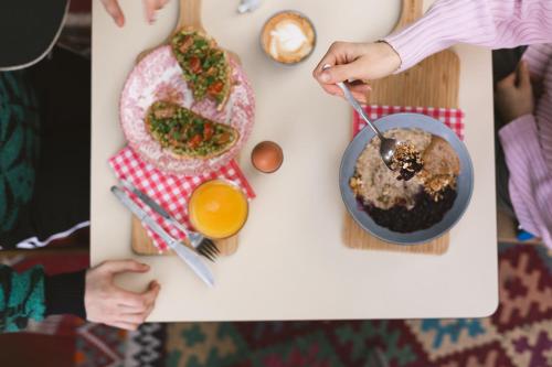 a table with a plate of food and a person eating food at Hostel Ani&Haakien in Rotterdam