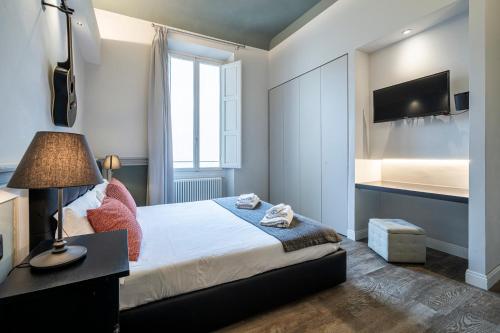 a bedroom with a large bed and a television at Cherubini Palace Thematic Apartment in Florence