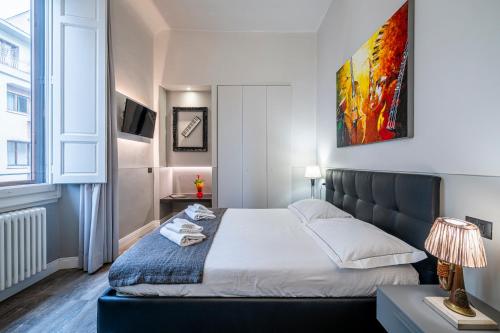 a bedroom with a bed and a large window at Cherubini Palace Thematic Apartment in Florence