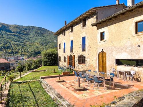a stone building with a table and chairs on a patio at Aiguabella - Allotjaments Rurals in Sant Felíu de Pallarols