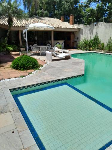 a swimming pool in front of a house at Mansão Mar casado in Guarujá