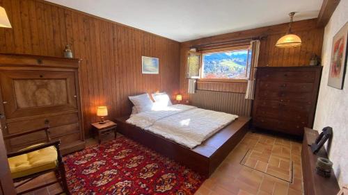 a bedroom with a bed and a window and a rug at Chalet familial à Megève, vue sur le village in Megève
