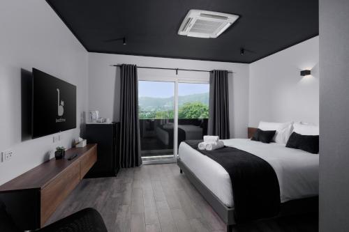 BedTime Hotel Samui في شاطئ تشاوينغ: غرفة نوم بسرير ونافذة كبيرة