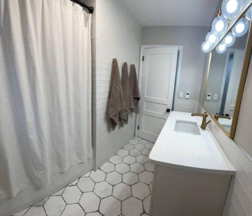 a bathroom with a shower and a sink and a mirror at The Warm & Inviting Place in Sioux Falls