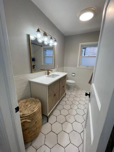 a bathroom with a sink and a mirror and a toilet at The Warm & Inviting Place in Sioux Falls