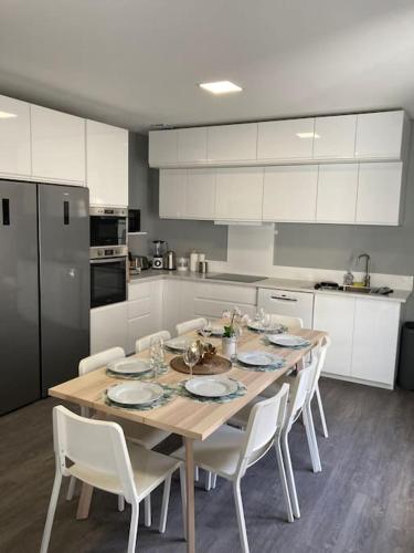 une cuisine avec une table en bois et des armoires blanches dans l'établissement La chambre du coliving proche gare, à Agen