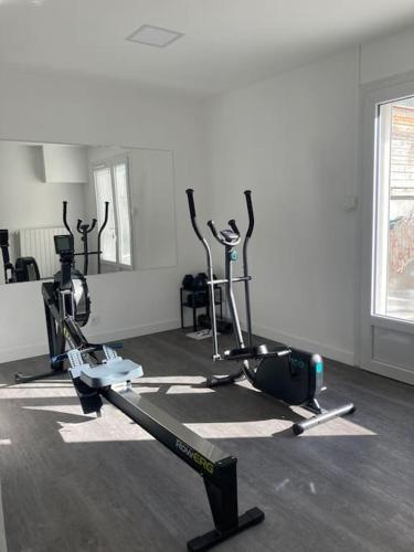 une salle de sport avec plusieurs machines de course dans une pièce dans l'établissement La chambre du coliving proche gare, à Agen