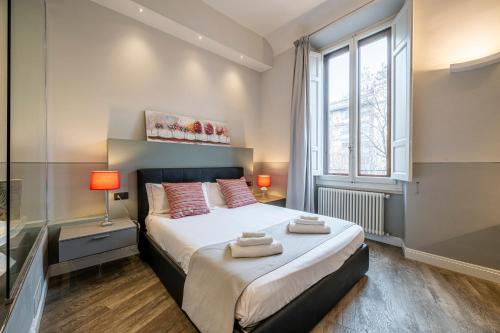 een slaapkamer met een bed, 2 lampen en een raam bij Cherubini Palace Thematic Apartment in Florence