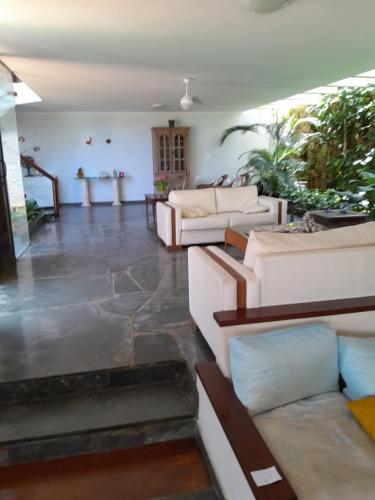 a large living room with couches and a table at Mansão Mar casado in Guarujá