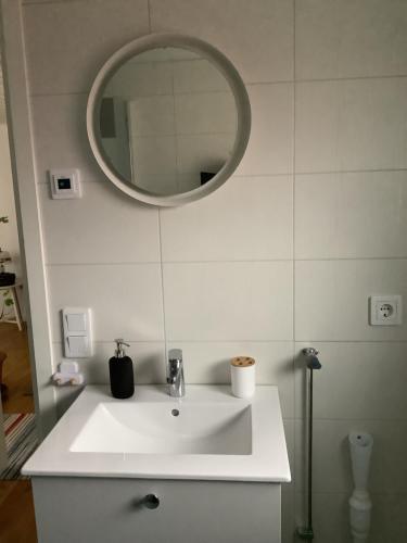 a bathroom with a white sink and a mirror at Skönaste stället som finns. Bara 300 m till havet. in Lysekil