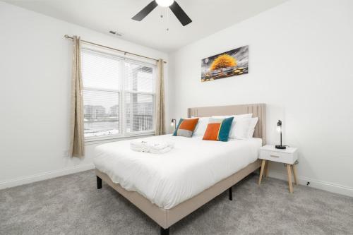 um quarto branco com uma cama grande e uma janela em Corporate Housing by MGM em Whitestown