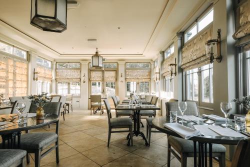 a restaurant with tables and chairs and windows at Victoria in Holkham