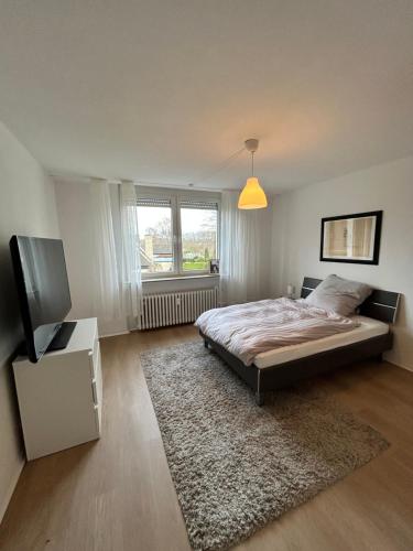 een slaapkamer met een bed en een flatscreen-tv bij geräumige Ferienwohnung Emsaue in Rheine