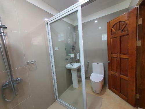 a bathroom with a shower and a toilet and a sink at Glorias Panglao Inn 2 (Family/Group Rooms) in Dauis