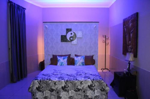 a purple bedroom with a large bed in a room at Villa Aurora Lovina in Lovina
