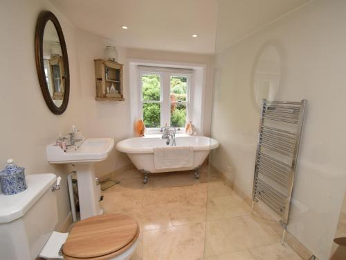 a bathroom with a tub and a sink and a toilet at 4 Bed in Lulworth Cove DC182 in West Lulworth