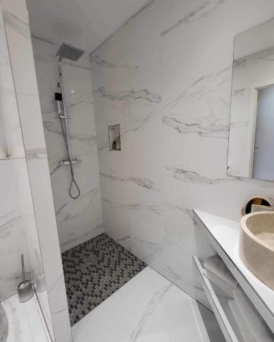 a white bathroom with a shower and a sink at les charmes de la vallée noble in Soultzmatt