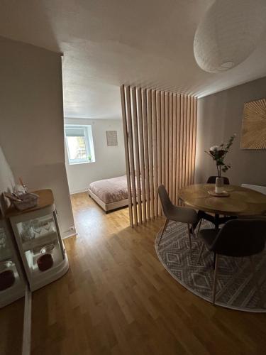 a small living room with a table and a bed at Dieppe F2 pour 4 personnes emplacement idéal 2 min à pied de la plage et des boutiques in Dieppe