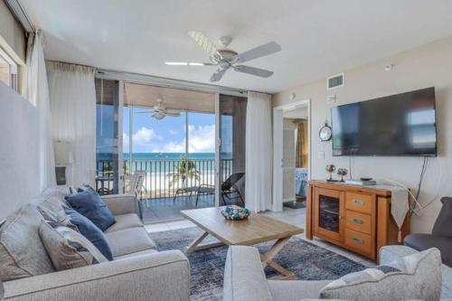 フォートマイヤーズビーチにあるBeach Villas # 201 - BOGO24 condoのソファとテレビのあるリビングルーム