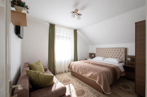 a bedroom with a bed and a couch at CASUTA LANGA LAC in Colibiţa