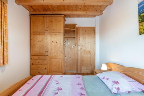 a bedroom with a bed and a wooden cabinet at Ferienwohnung Toni II in Siusi
