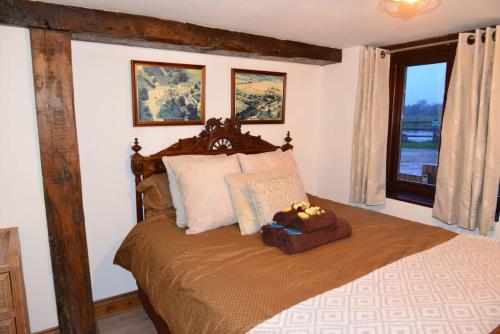 una camera da letto con un grande letto con una grande finestra di River Avon Retreat - A Rustic Gem On The Riverbank a Fordingbridge
