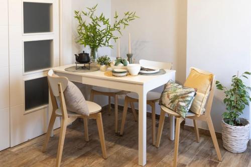 a white dining room table with chairs and plants at Apartamento para 4 con Jardín a 500m de la Playa in Altafulla