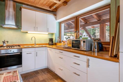 a kitchen with white cabinets and a window at Ferienwohnung Toni II in Siusi