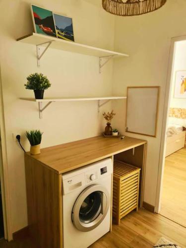 une buanderie avec une machine à laver dans une pièce dans l'établissement Charmante maisonnette - St naz- Comme à la maison, à Saint-Nazaire