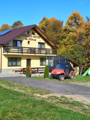 a red jeep parked in front of a building at Pensiunea Natura Sadu in Sibiu